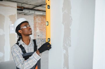 Construction worker checking vertical alignment with spirit level