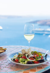 Greek salad and wine in Greece in a restaurant. Selective focus.