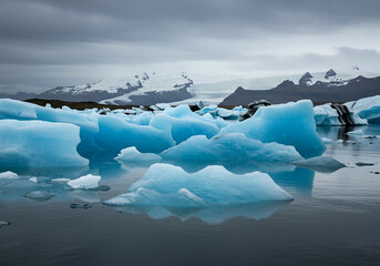 arctic iceberg in glacier-fed lagoon with blue ice reflection