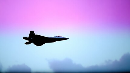 Silhouette of a military fighter jet in flight against a gradient sky with pink and blue hues