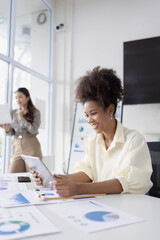 Fototapeta premium Two business woman working together for analysis data plan business strategies in office, Business discussing and startup concept.