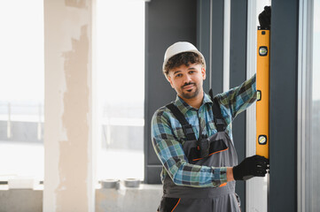 Obraz premium Construction worker using spirit level on window frame