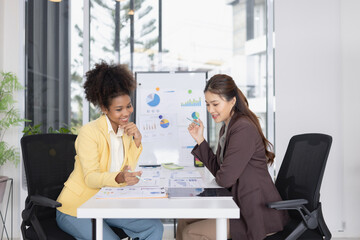 Two business woman working together for analysis data plan business strategies in office, Business discussing and startup concept.