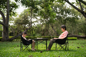 Family outdoor time with parent and child, peaceful garden setting, laptop use for work and play, quality moments in green park space