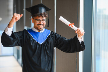 Happy arab student celebrating graduation with diploma in university building