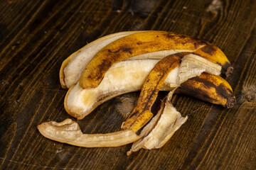 banana on a black pine wood table , blackening old ripe banana whose color changes to black, close...