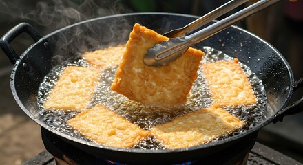 Golden Fried Food Cooking in Hot Oil with Metal Tongs
