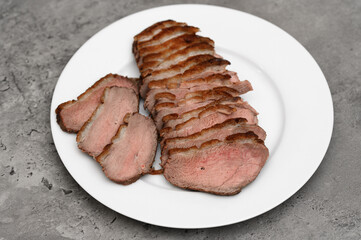 Fried duck breast cut into slices on a plate