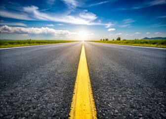 Naklejka premium A long straight road stretches to the horizon under a bright sky with a yellow line