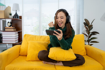 Enthusiastic Gamer Embraces Victory: A young woman experiences pure elation, immersed in her mobile...
