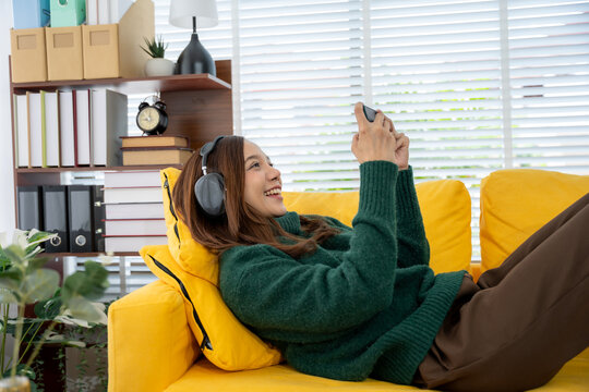 Cozy Leisure: Woman Enjoys Digital Time on Sofa