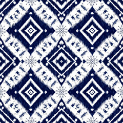 A striking seamless pattern features a modern ikat design in classic navy blue and white, perfect for contemporary textile and background applications.