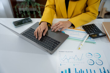 Analyzing Data: A professional in a yellow blazer concentrates at a desk. They're deeply engaged...