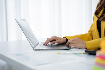 Fototapeta premium Business Woman Working on a Laptop: A professional is diligently focused on her laptop, fingers dancing across the keyboard as she works with determination and concentration.