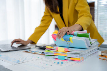 Organized Workspace: A professional meticulously organizes colorful files and documents on a desk,...