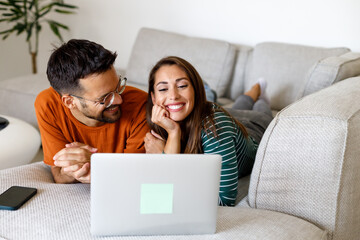 Man and woman use credit card and laptop for online shopping at home