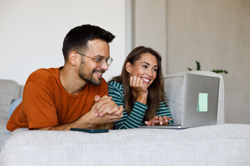 Man and woman use credit card and laptop for online shopping at home
