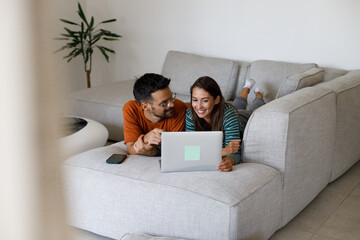 Man and woman use credit card and laptop for online shopping at home