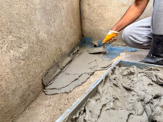 Applying Waterproofing Cement Mixture in a Building Corner