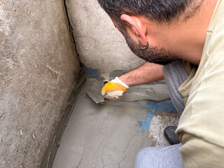 Overhead View of a Man Repairing a Concrete Floor Corner