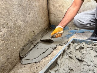 Builder Plastering a Floor Joint for Waterproofing