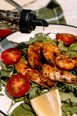 Olive oil drizzled gently over grilled shrimp and greens, bringing out all the Mediterranean aromas.