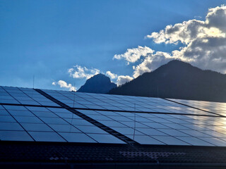 romantic advertising photo of an industrial hall in evening. solar panels on flat roof and in...