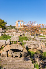 Temple of Apollo and surrounding stone ruins in ancient Corinth, Greece on a sunny day