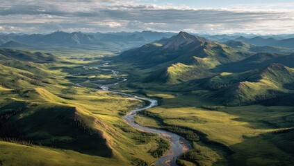 Fototapeta premium High-angle view of winding river valley, lush green hills, and distant mountains