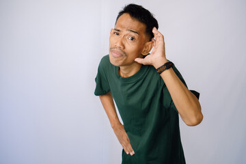 Attentive Person In Green Shirt Listening Carefully Against A Plain Background