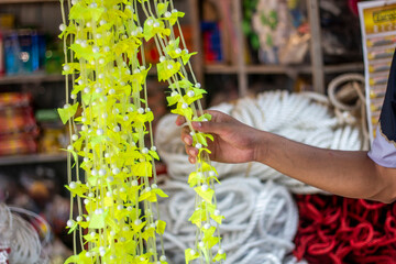 A man holds yarn paper flowers in the market