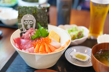 sashimi mixed fresh set japanese food with rice bowl. Salmon, Tuna fish, seafood and wasabi in restaurant. Kamakura Food with Buddha face is famous in Kangawa prefecture, Japan