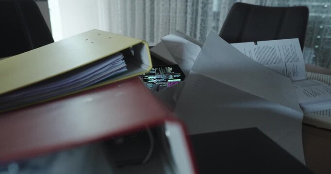 A smartphone running AI code is barely visible under messy documents and binders&mdash;symbolizing the silent presence of artificial intelligence in chaotic office or study environments.