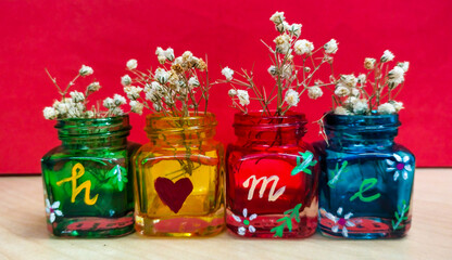 Flowers in colorful glass jars, forms the word HOME 