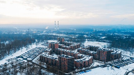 Modern housing development surrounded by snowy forest