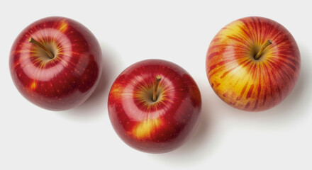 Three red apples are arranged on a white surface with soft shadows.
