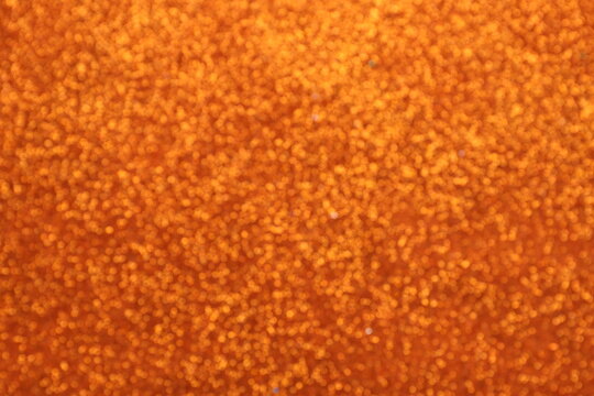 Blurred shiny orange glitter texture background