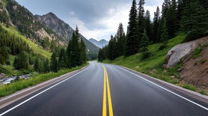 Fototapeta premium A winding road through a mountainous landscape, surrounded by evergreen trees and dramatic cliffs under a cloudy sky.