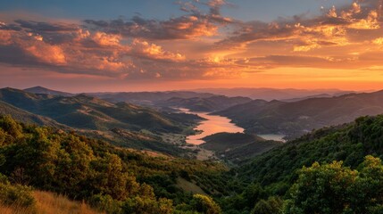 Fototapeta premium Orange and Pink Sunset Over a Valley Between Hills and Lake