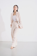 白背景で撮影をしたジャケットを着た若い女性のスタイリッシュなポートレート