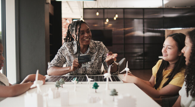 Black female teacher teaches and instructs primary girls group students, clean energy lesson at learning table in science classroom, discusses experiment knowledge for children of elementary school. - Powered by Adobe