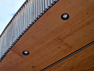overhang of a theater stage made of wood materials with decorative plank strips. Backlit with spot...
