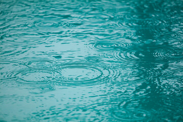 A body of water with raindrops falling on it