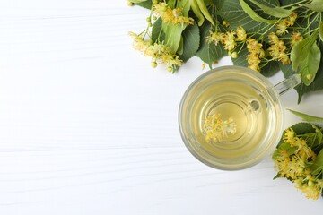 Aromatic green tea with fragrant linden in white cup on gray background