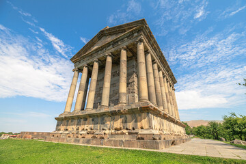 Garni Temple, a first-century hellenistic ionic temple near Garni, Armenia, stands majestically against a vibrant blue sky, showcasing its well-preserved columns and intricate stonework