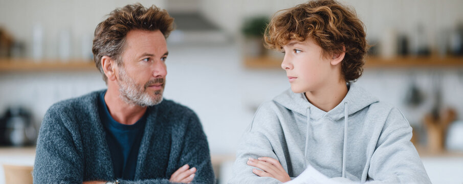 Father and son face each other in thoughtful contemplation. Captures family dynamics, generational discussions, parenthood, bonding and understanding. - Powered by Adobe