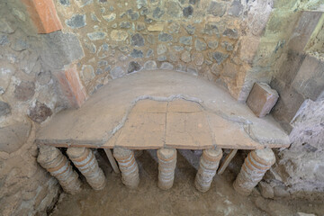 Hypocaust heating system with brick pilae supporting the floor in the roman bath ruins of Garni Archaeological Complex in Armenia, showing ancient roman engineering and architecture