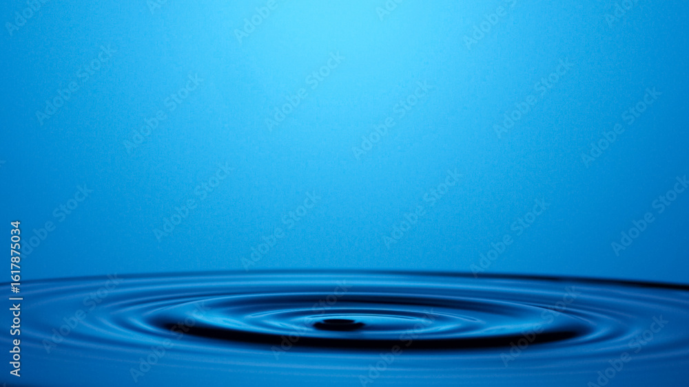 Poster tranquil ripple: a mesmerizing view captures the moment a single drop of water disrupts the serene s