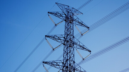 Power lines against sky: a striking visual of an electricity pylon, with cables reaching across a...