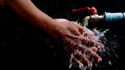 Cleanse and Refresh: A pair of hands, gently cradling themselves under a stream of water, capturing...
